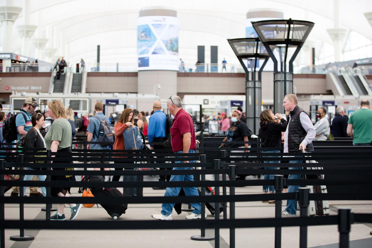 People make their way through the security line at Denver International Airport