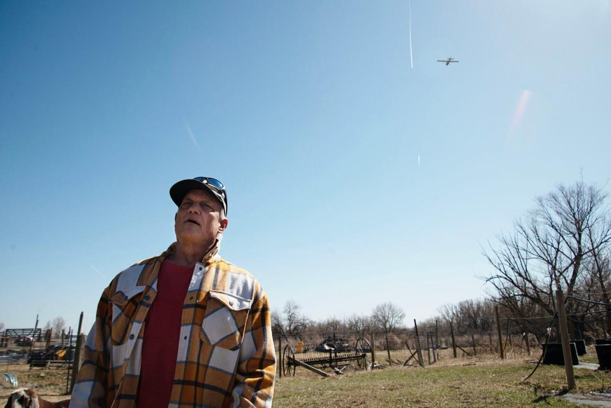Hep Ingram surveys his property while a plane flies