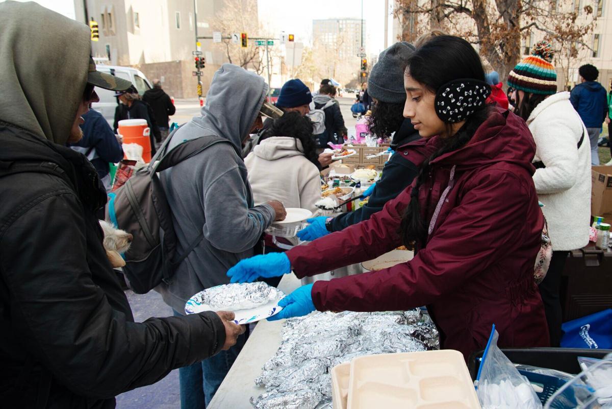 Hridya Nair, right, hands out food items to the hungry