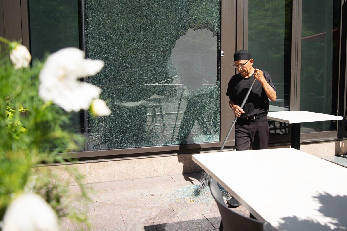 A worker cleans up broken glass outside of the Thirsty Lion Gastropub
