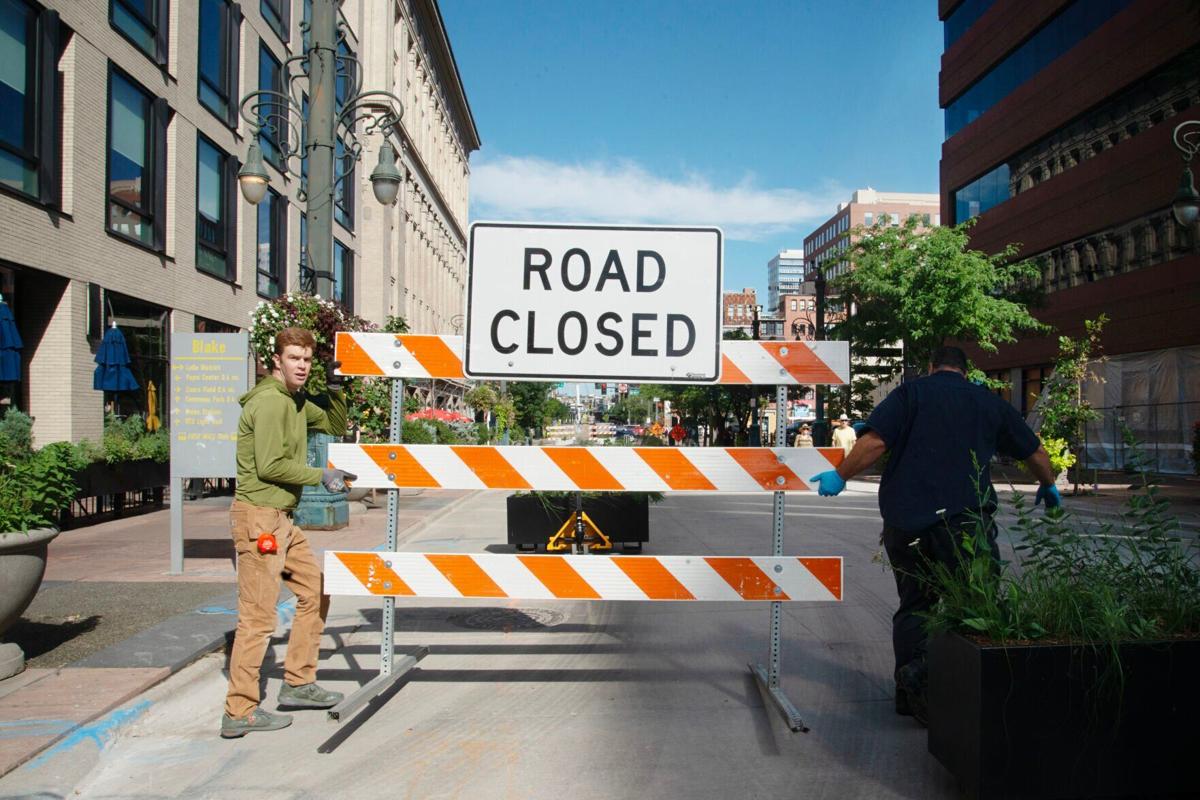 Brandon Johnson, left, and Ray Ortiz remove road closure signs (copy)