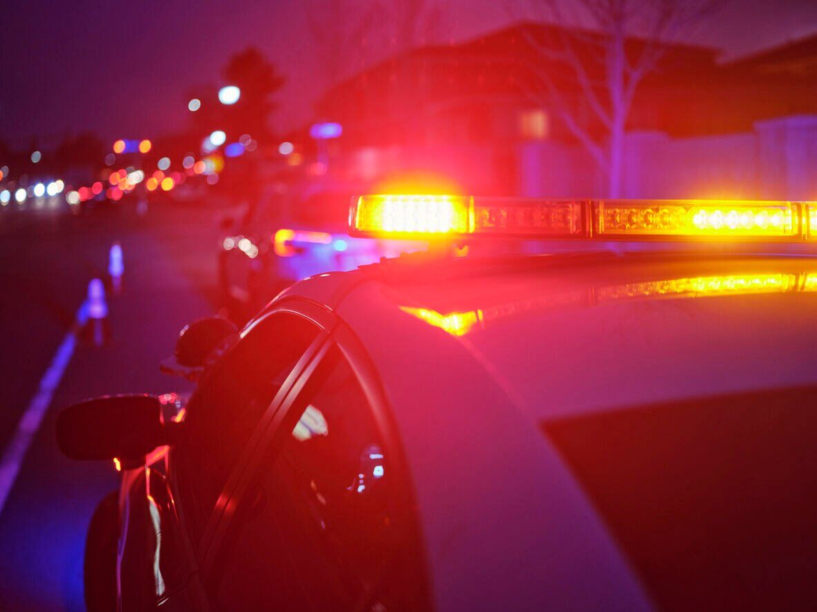 Police Car Stopped on a Road at Night with Emergency Lights Photo: RichLegg (iStock).