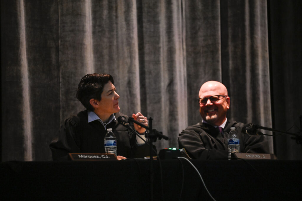 Colorado Supreme Court Chief Justice Monica M. Márquez,  left, asks a question alongside Justice William W. Hood III during arguments at East High School for Courts in the Community on Thursday, Oct. 23, 2025. (Stephen Swofford, The Denver Gazette)