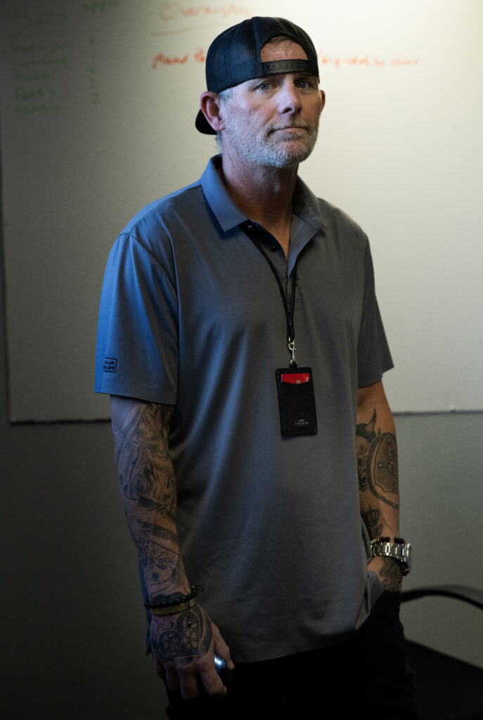 A man stands alone in a gray room.