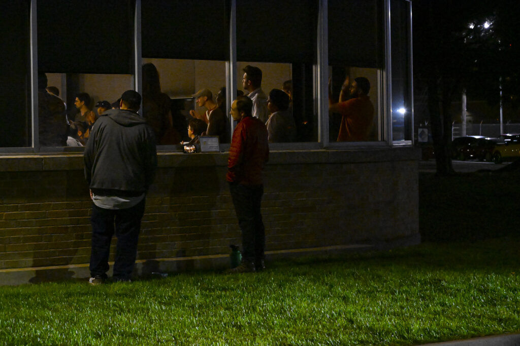 People looking in a window at a community town hall meeting