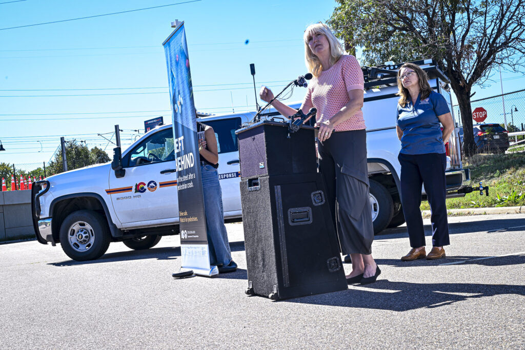 a woman with blond hair stands behind a podium