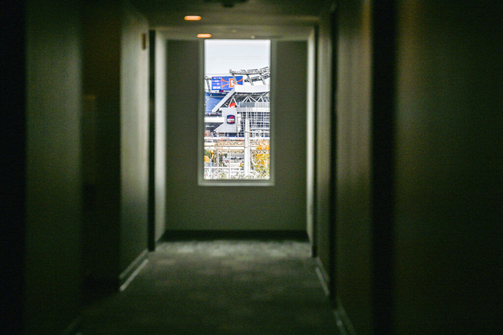 a square window at the end of a long hallway in an apartment building