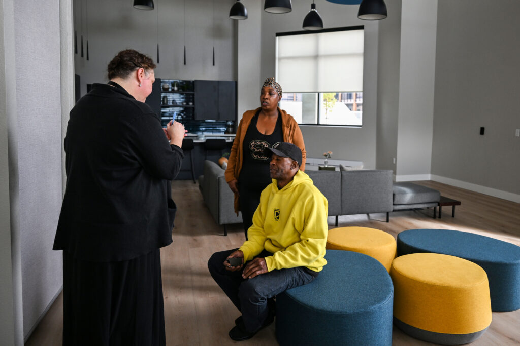 three people chat in the common areas of a new modern apartment building 