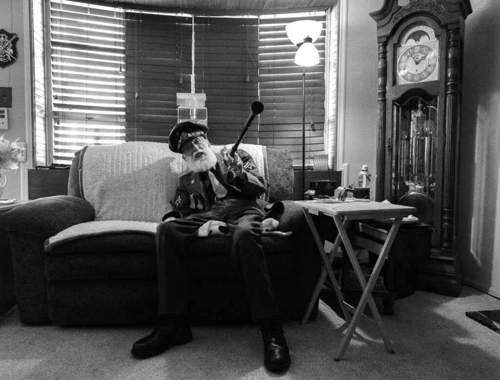 A WWII veteran points out a clock in his home.
