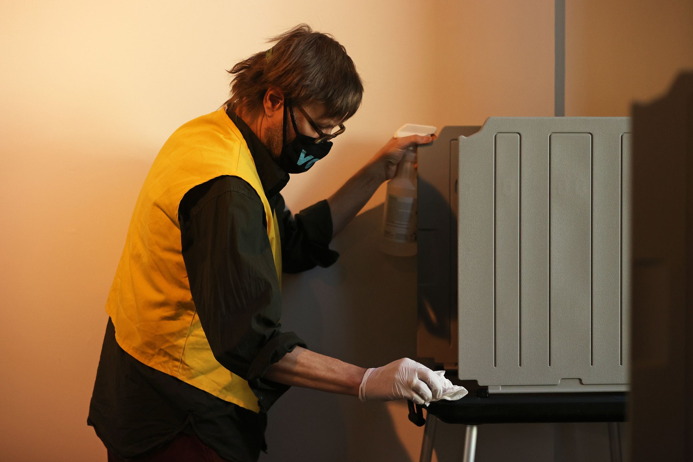 Election Judge Steve Harley wipes down a voting station with disinfectant after it was used by a voter at the McNichols Civic Center Building at Civic Center Park in downtown Denver, Colorado on Oct. 29, 2020. (Forrest Czarnecki/The Gazette)