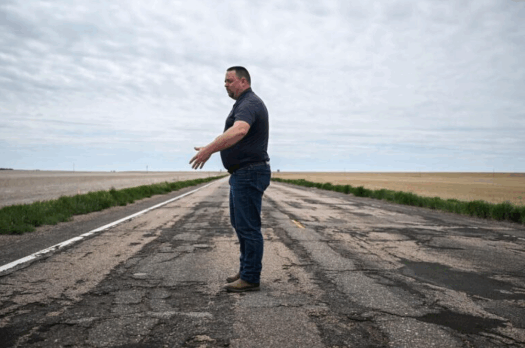 A man standing on a decrepit roadway
