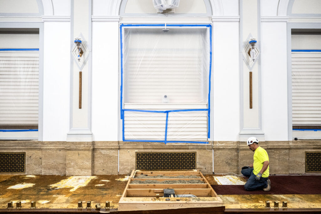 workers tearing up carpet in city council chambers