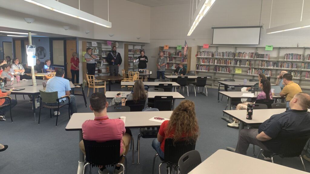 people seated in a small middle school library