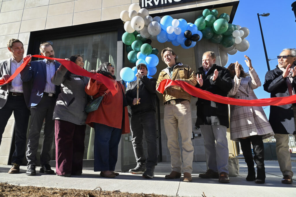 city officials cut a red ribbon to mark the opening of a new building