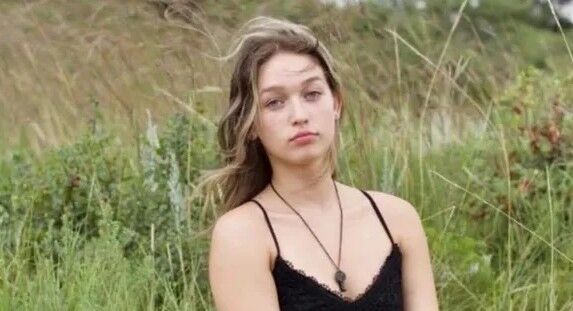 A photo of a woman against a grassy background