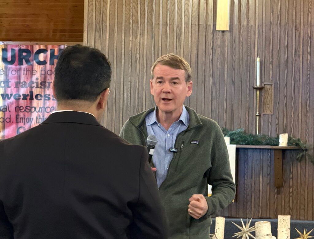 U.S. Sen. Michael Bennet, right, a Democratic gubernatorial candidate in Colorado, speaks with an attendee at a town hall on Feb. 7, 2026, at Good Shepherd Presbyterian Church in Northglenn. (Ernest Luning/Colorado Politics)