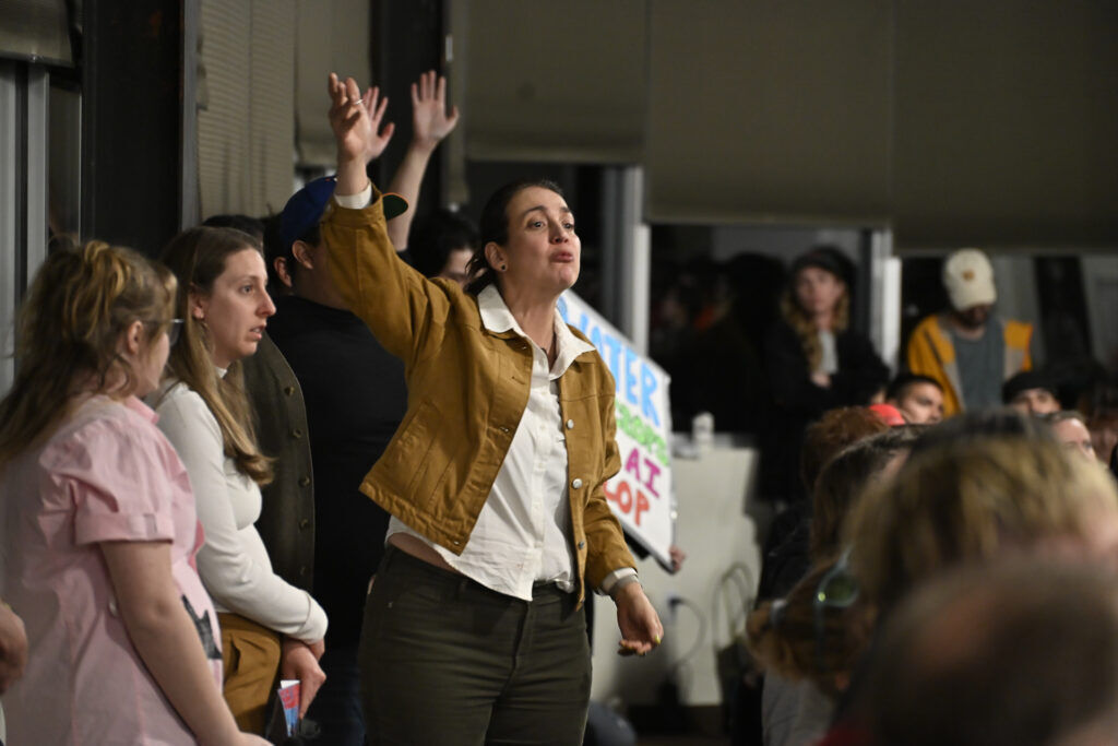 a woman gestures a public meeting 