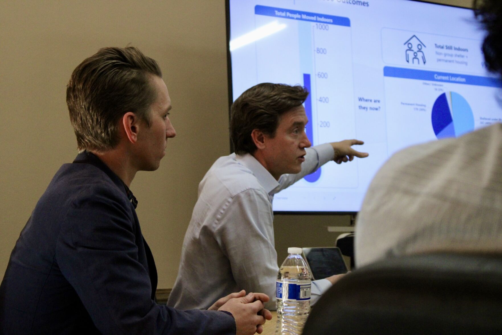 two men sitting by a projector