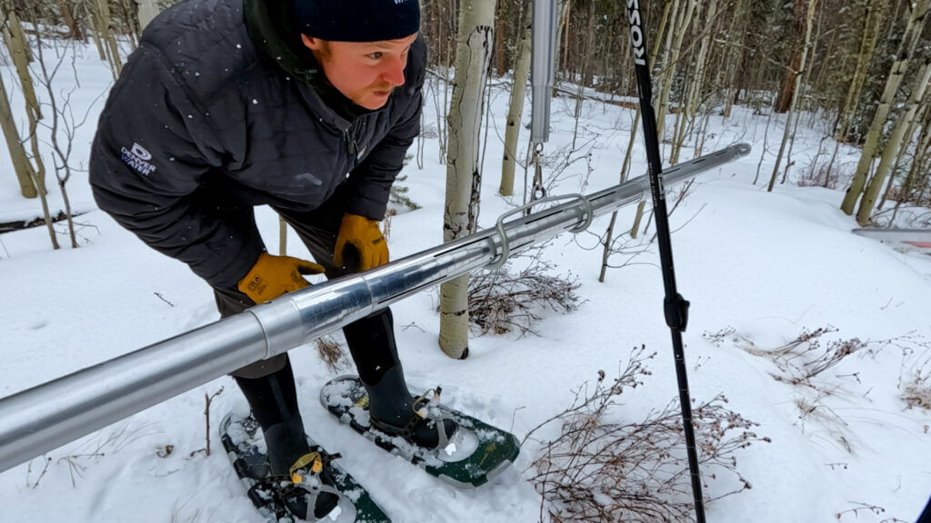 a person measuring snowpack
