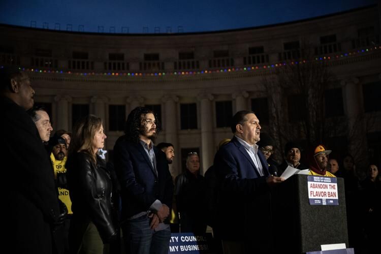 a group of people gathered behind a podium in front of a government building