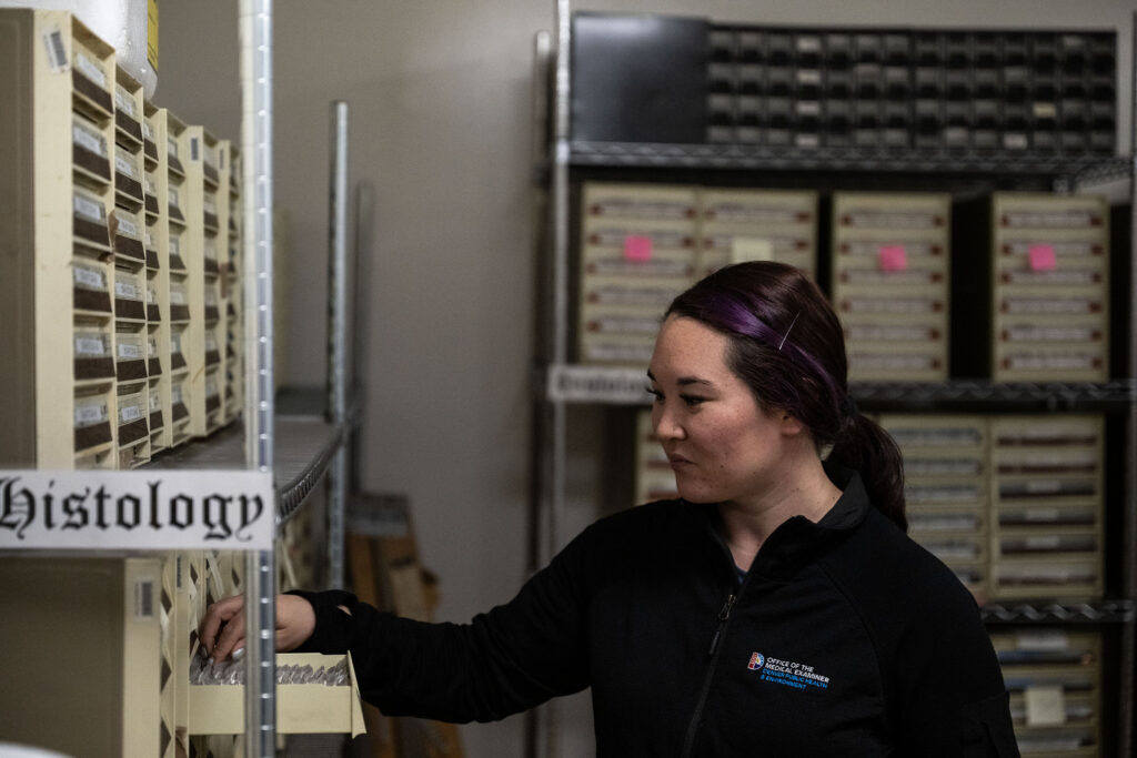 Hanah Shimeall, a medicolegal death investigator with the Denver Medical Examiner’s office, shows histology slides from as far back as the 80’s during a tour through the facilities on Thursday, May 21, 2026.
