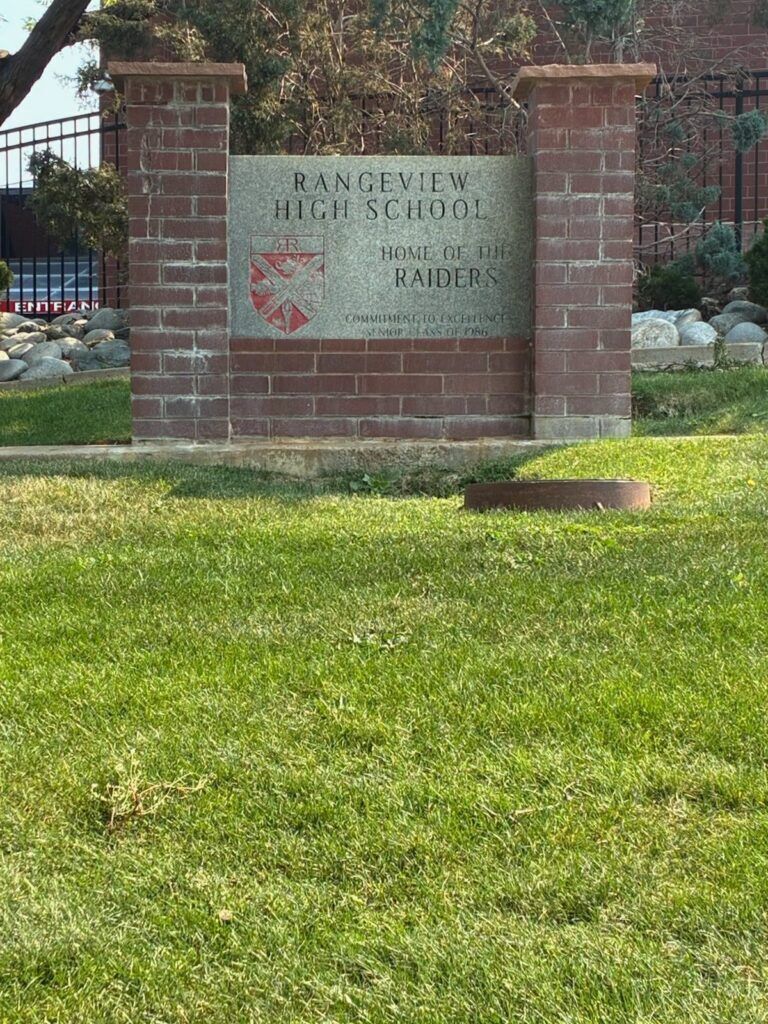 Green grass in front of a Rangeview High School sign.