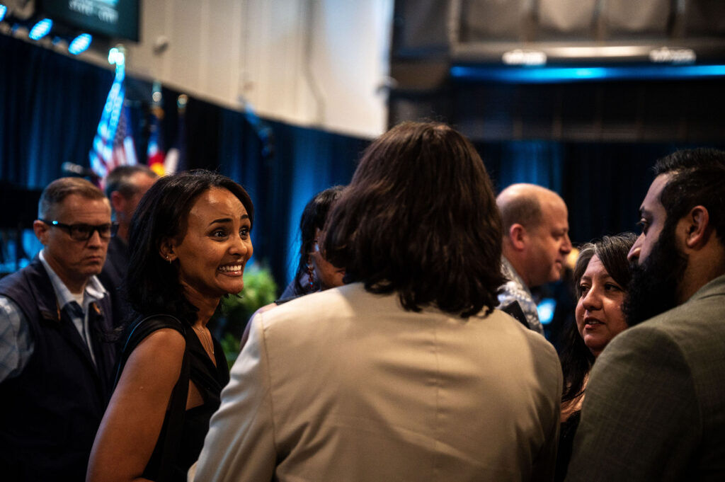 Melat Kiros talks with other guests near her seat before the start of Denver Mayor Mike Johnston’s state of the City address at the National Western Center on Tuesday, July 21, 2026.