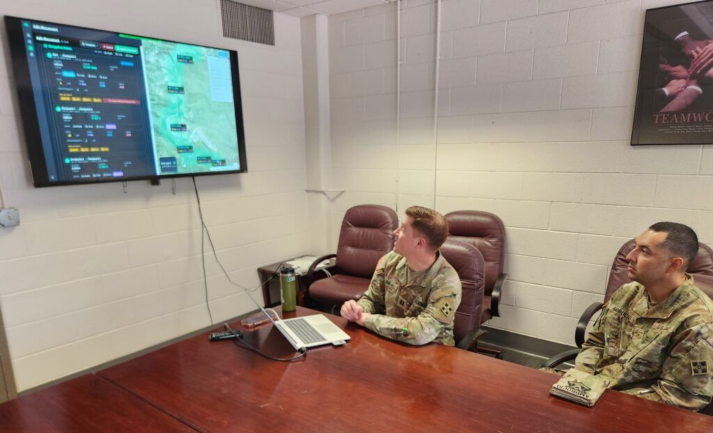 Capt. Christopher Reif, a software operations officer and Warrant Officer One Jesus Ambrocio, a software operations technician describe the convoy ops application displayed on the screen on June 26, 2026. Mary Shinn, The Gazette 