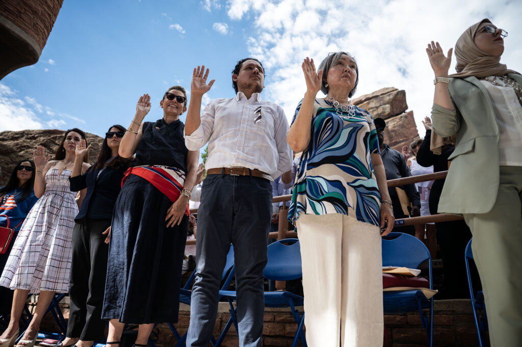 People swear the oath of allegiance, becoming U.S. citizens, during a naturalization ceremony at Red Rocks on Thursday, July 30, 2026 in Morrison, Colo. (Stephen Swofford, Denver Gazette)