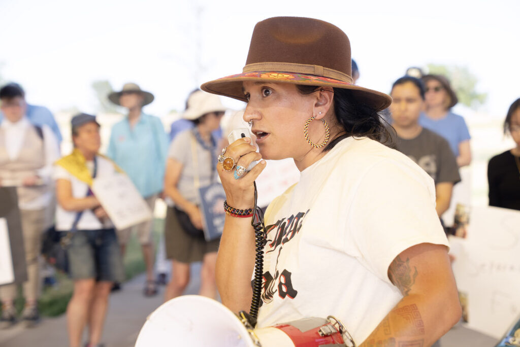 A woman speaks into a bullhorn