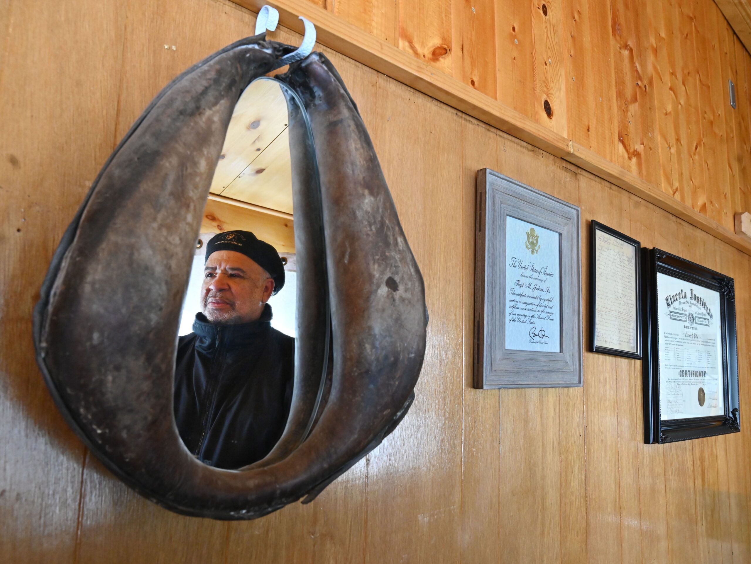 Retired Judge Gary Jackson is reflected in a horse collar mirror next to historical photos and documents of Lincoln Hills. (Timothy Hurst, The Gazette)