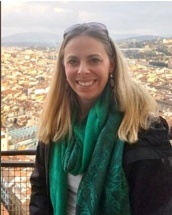 A picture of Lindsay Banett who is smiling with a city in the background