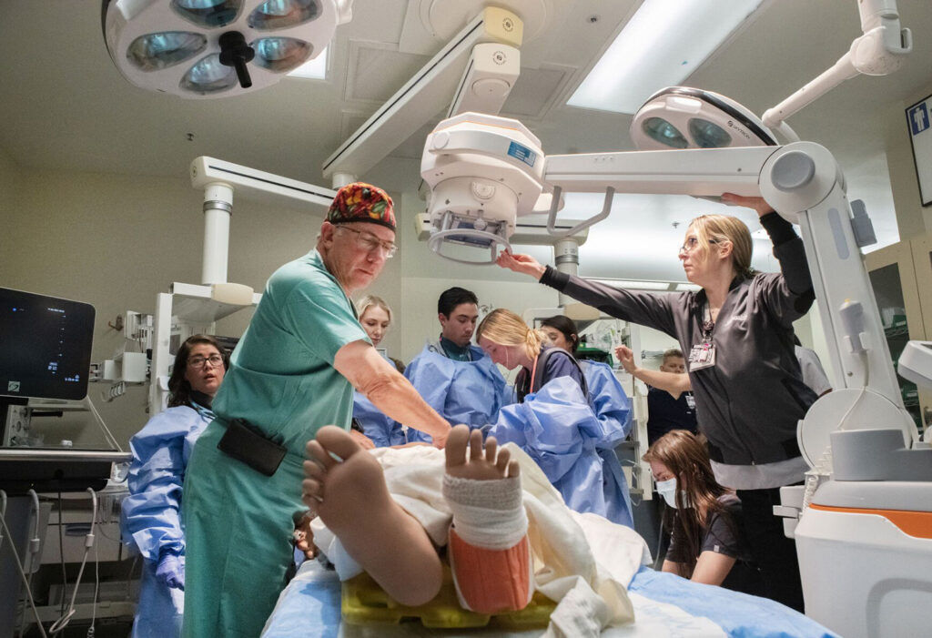 Image shows medical providers at work at Memorial Hospital in Colorado Springs. Trauma surgeon Paul Reckard, left, and the trauma team treat a motorcycle crash patient during a Simulated Trauma Alert Training Tuesday in the Emergency Department at UCHealth Memorial Hospital Central. (Christian Murdock, The Gazette)