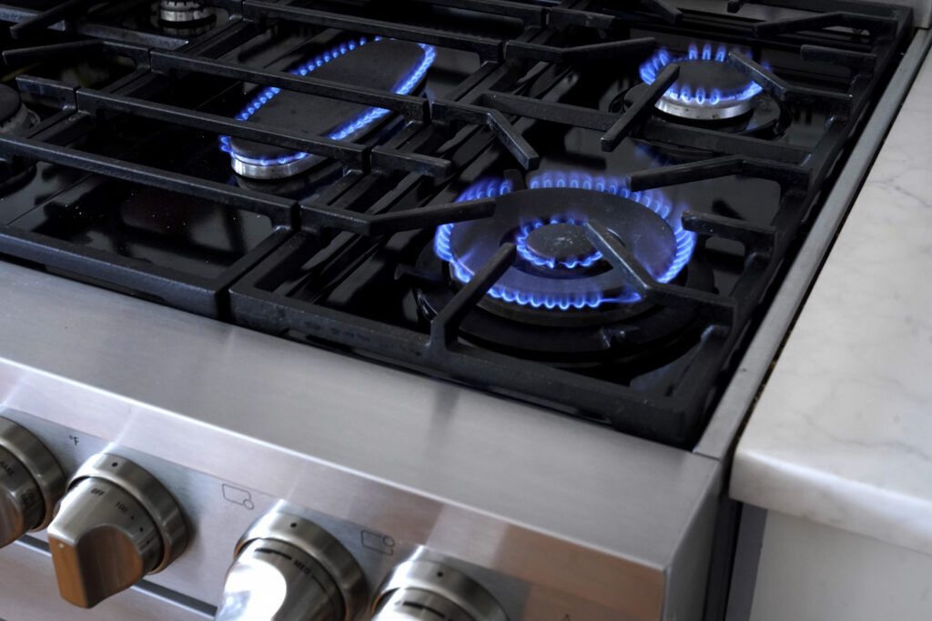 Flames emerge from burners on a natural gas stove. (Steven Senne, The Associated Press)